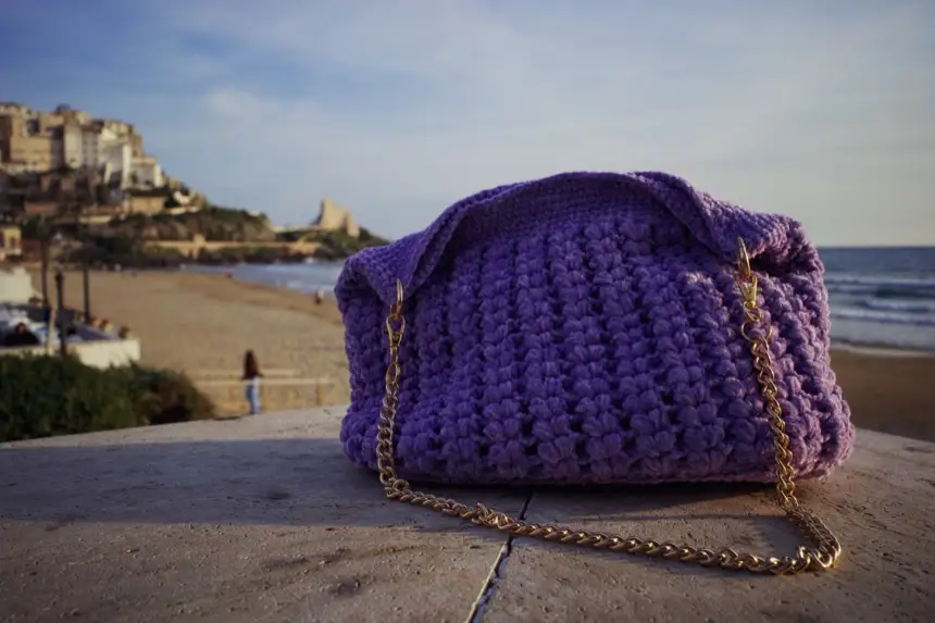 Borsa lilla all’uncinetto a punto soffiato con catenella dorata, il mare sullo sfondo