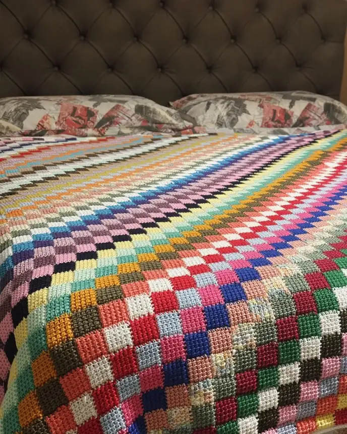 Coperta multicolore all’uncinetto distesa sul letto